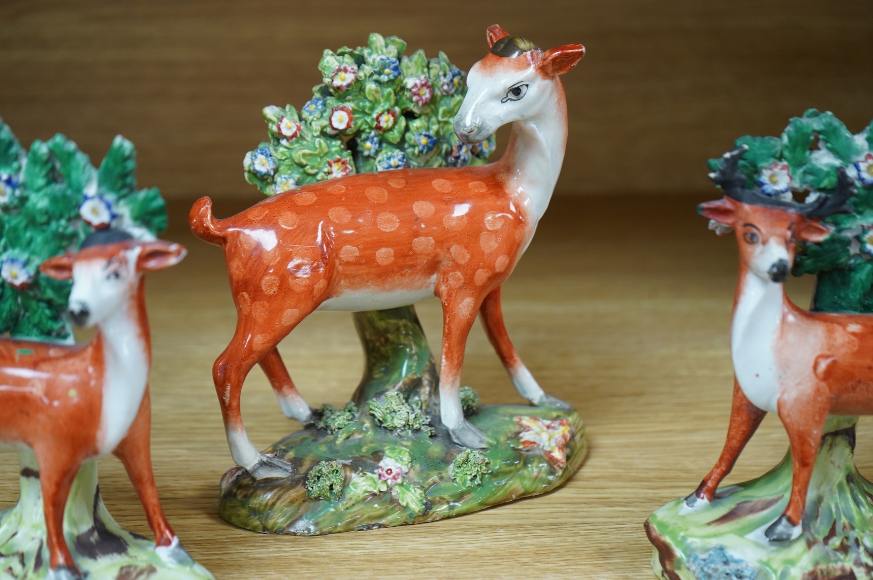 Three early 19th century Staffordshire pottery models of deer, largest 16cm high